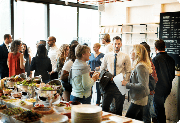 Group of business people networking next to a table filled with food